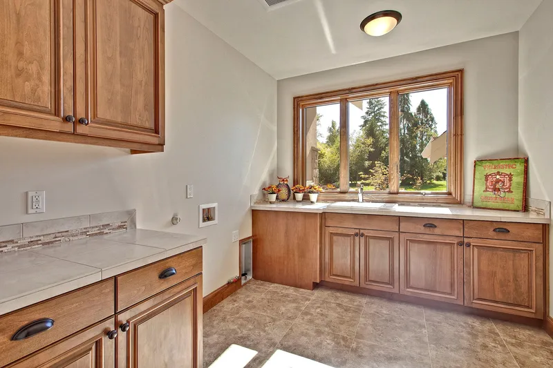Bear Creek: Utility room with wood cabinetry and a broad window