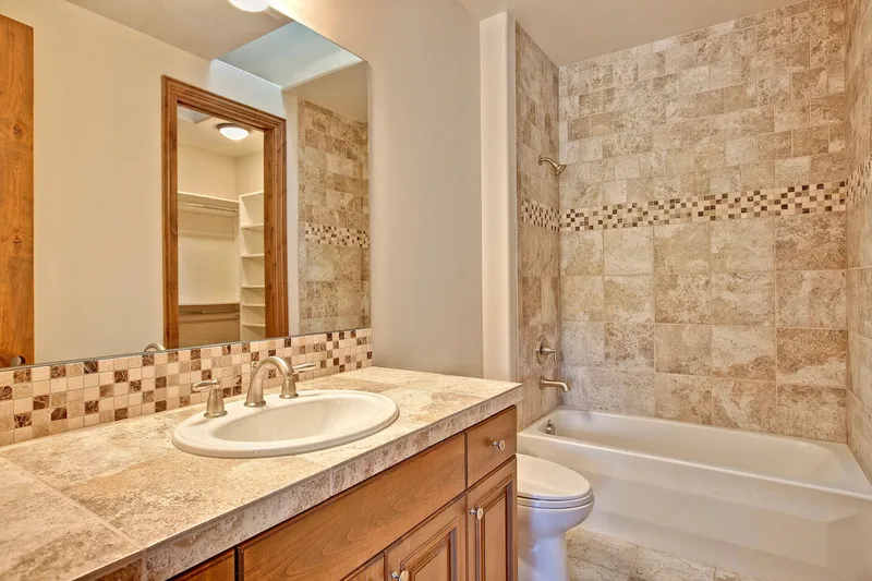 Bear Creek: Bathroom with a tiled tub surround and wood vanity