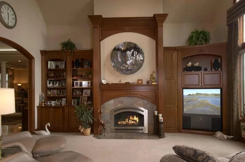 Duvall Valley: Media room with a wood-trimmed fireplace and display cabinets