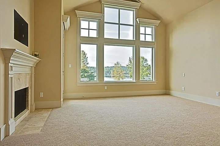 Eagle Shores, Lot 3: Vaulted room with a fireplace and a tall window
