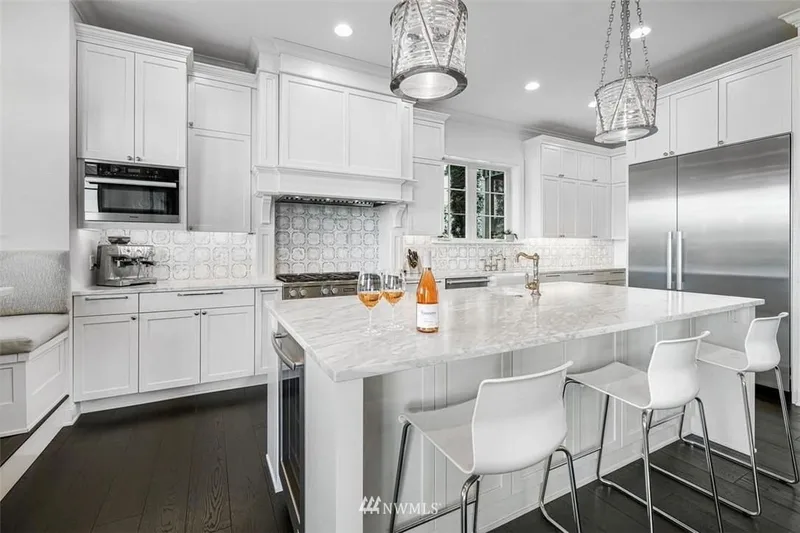 Mercer Island, Cape Cod: White kitchen with a central island and pendant lights