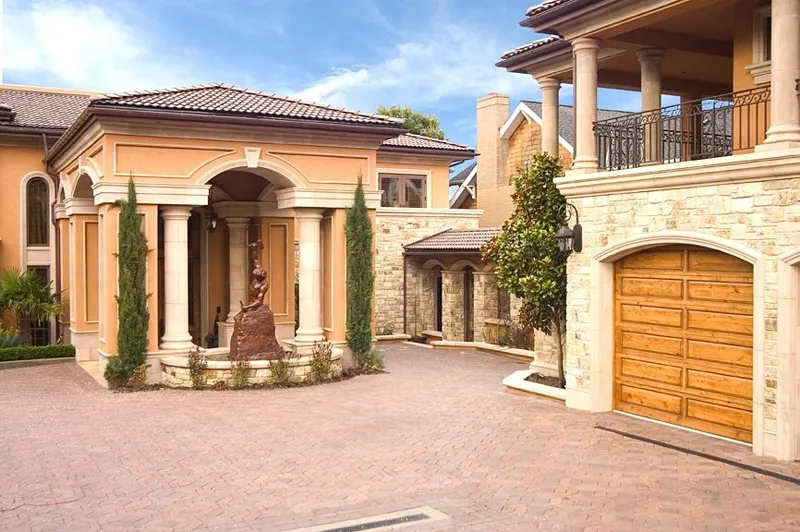 Mercer Island waterfront: Courtyard approach with columns, a fountain and garage doors