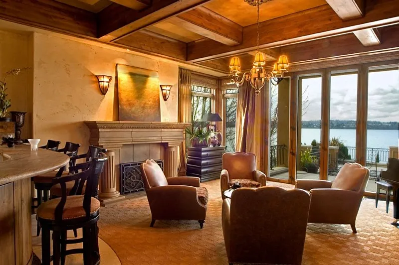 Mercer Island waterfront: Water-facing sitting room with a fireplace and glass doors
