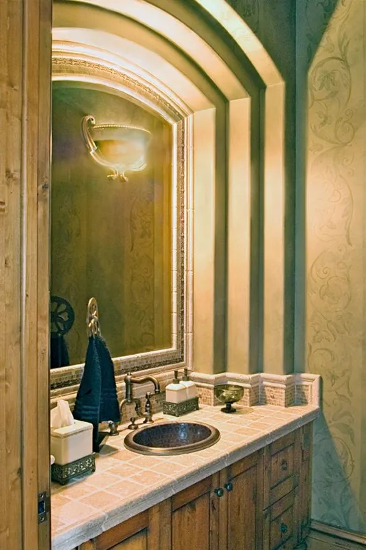 Mercer Island waterfront: Powder room vanity beneath an arched mirrored surround