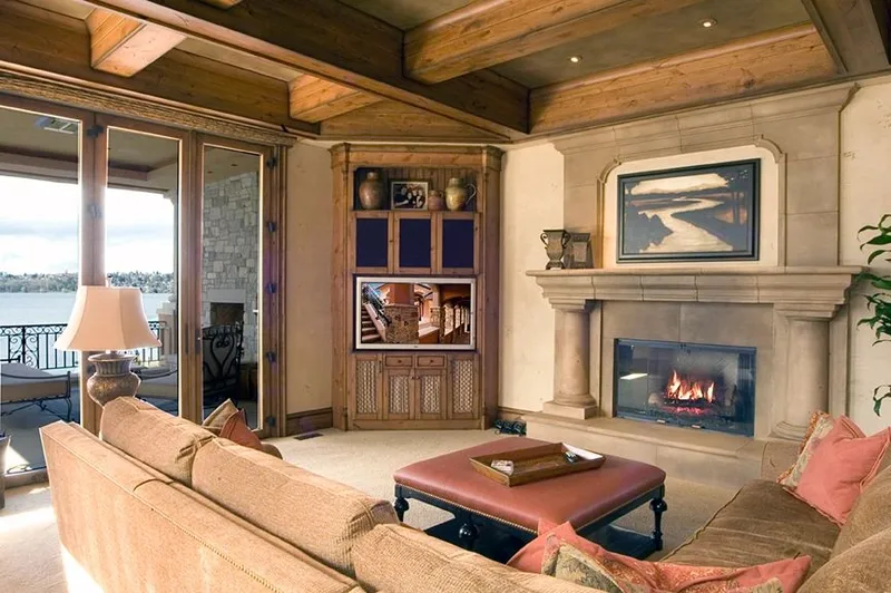Mercer Island waterfront: Living room with a fireplace, built-in cabinetry and wood ceiling beams