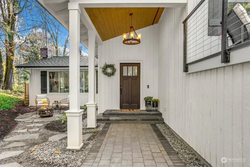Covered front entry with white posts and a wood ceiling