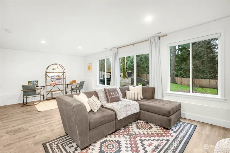 Lower living area with a fireplace and garden windows