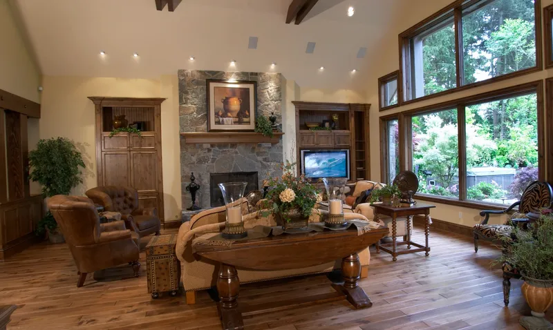 Woodinville Craftsman: Great room with a stone fireplace and broad garden windows