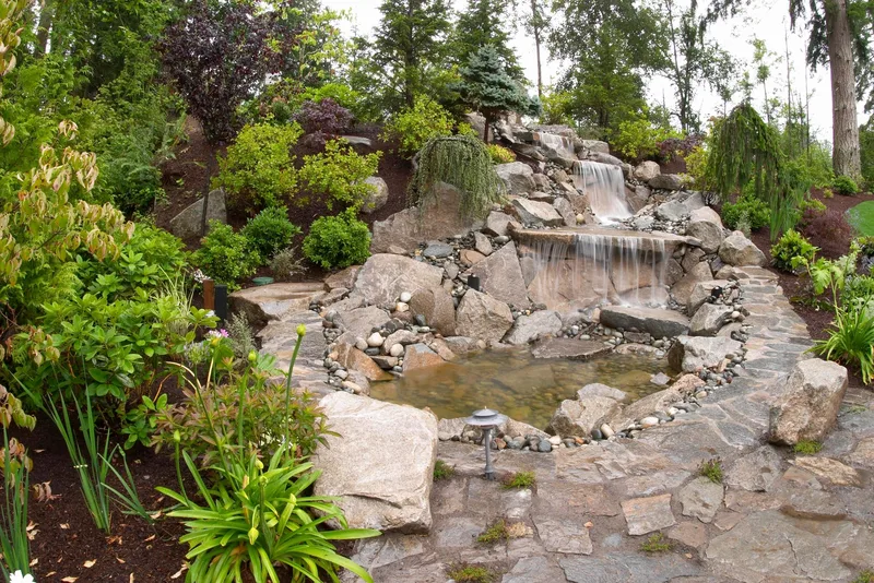 Woodinville Craftsman: Rock waterfall surrounded by garden planting