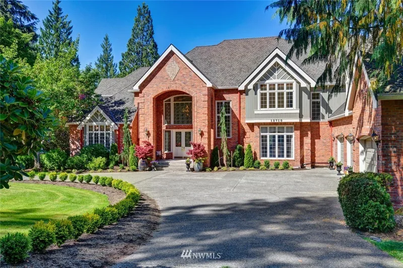 Brick-front Woodinville home with gabled rooflines and landscaped entry