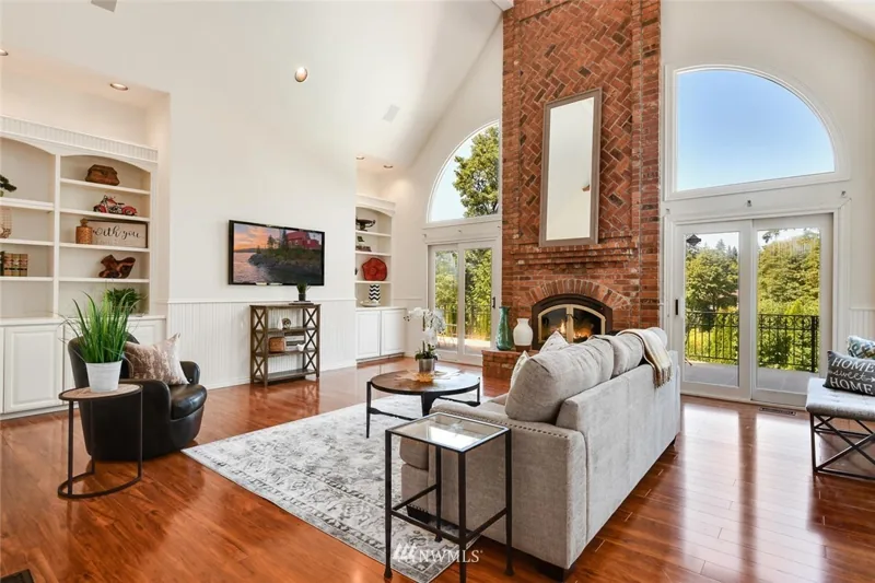 Family room with a tall brick fireplace and arched window