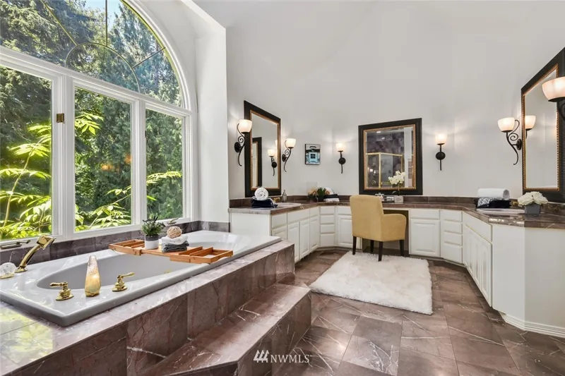 Bathroom with a window-side bathtub and two vanities