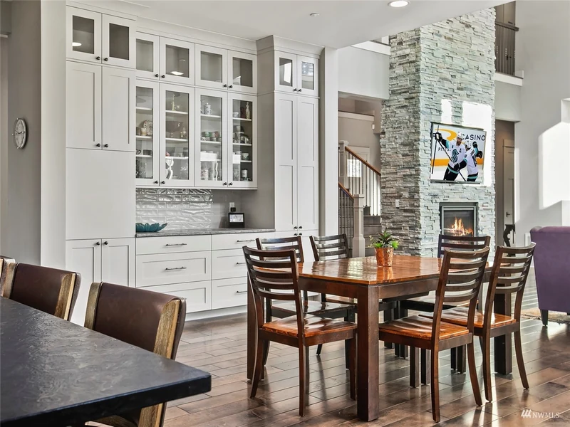 Dining area with built-in cabinetry beside the stone fireplace