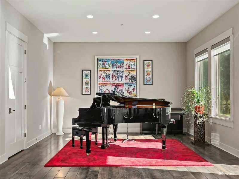 Piano alcove with tall windows and a red area rug
