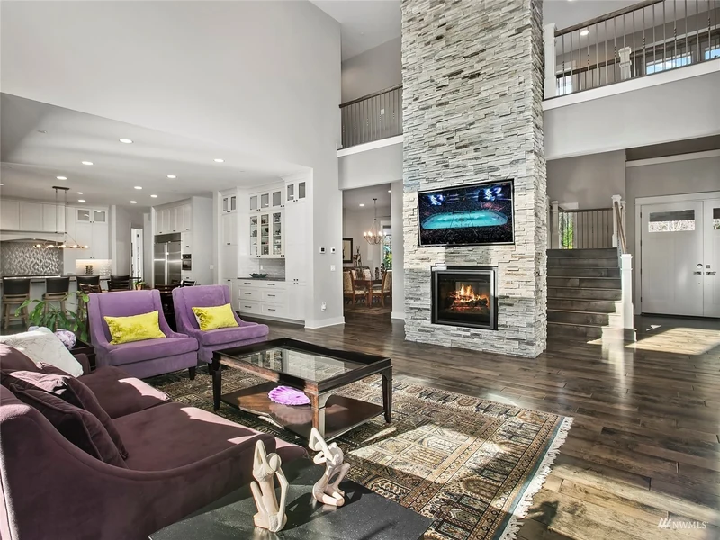 Great room seating beside the stone fireplace and open kitchen