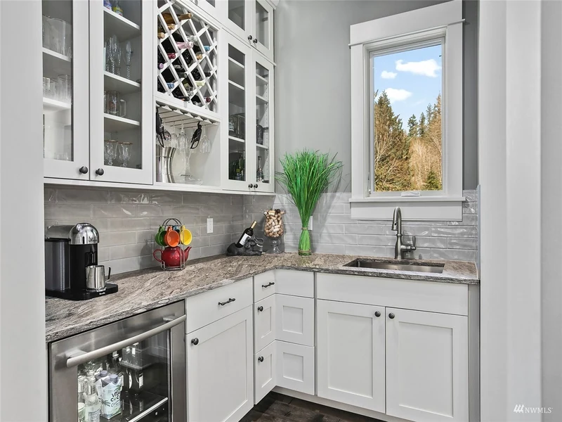 Butler pantry with glass-front cabinetry, wine storage and a sink