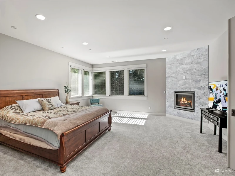 Bedroom with a fireplace, broad windows and a sitting area