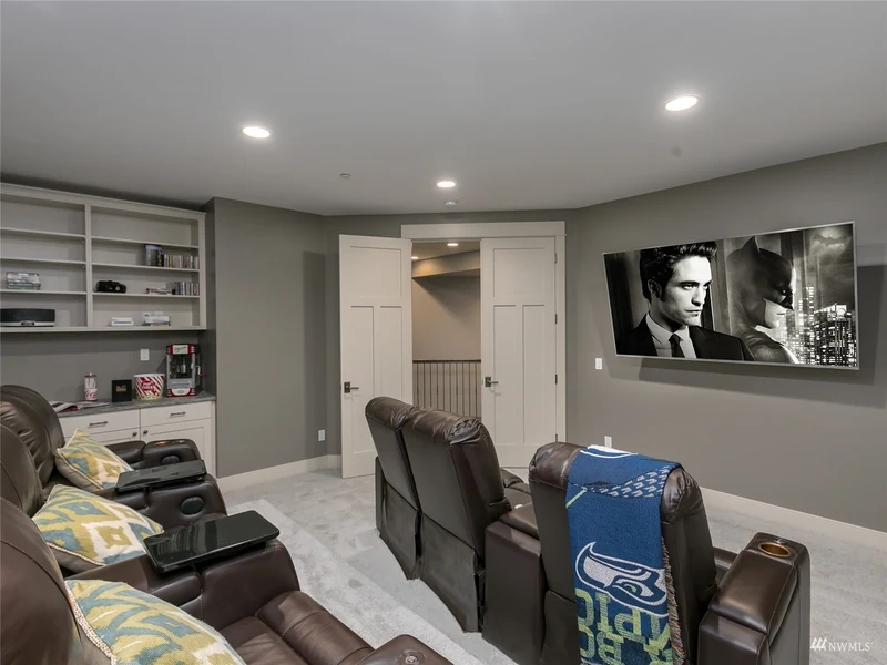 Home theater with reclining seats, a large screen and built-in cabinetry