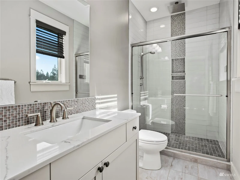 Bathroom with a tiled tub and shower enclosure