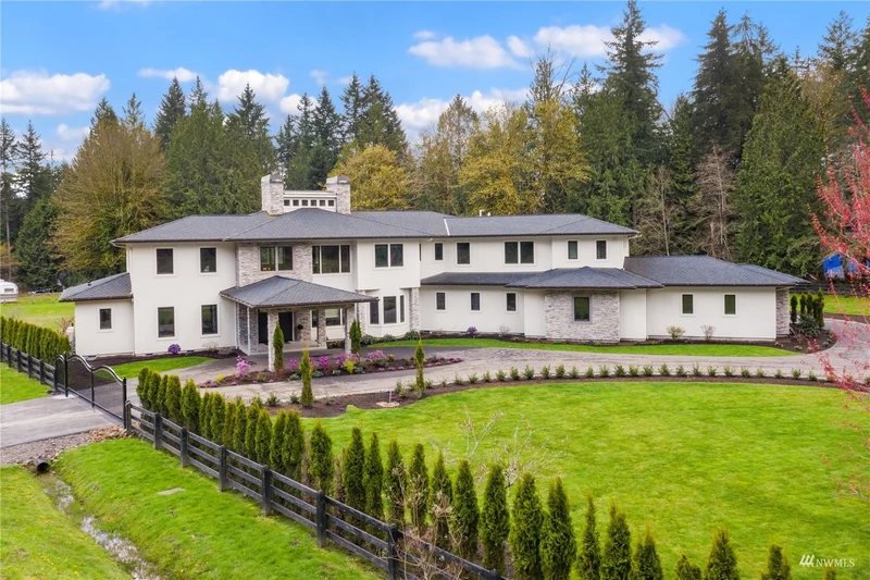 Woodinville home and landscaped lawn beneath a blue sky