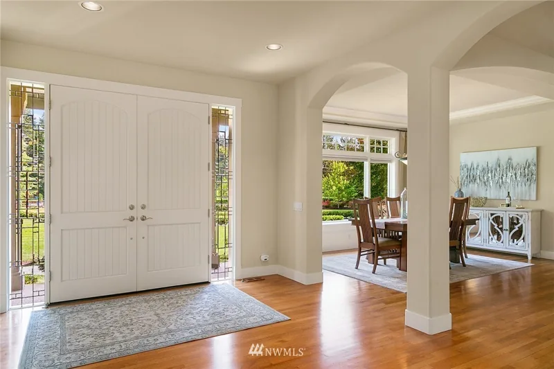 Entry with double doors, wood flooring and arched openings