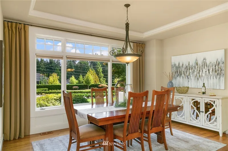 Dining room with a tray ceiling and wide garden window