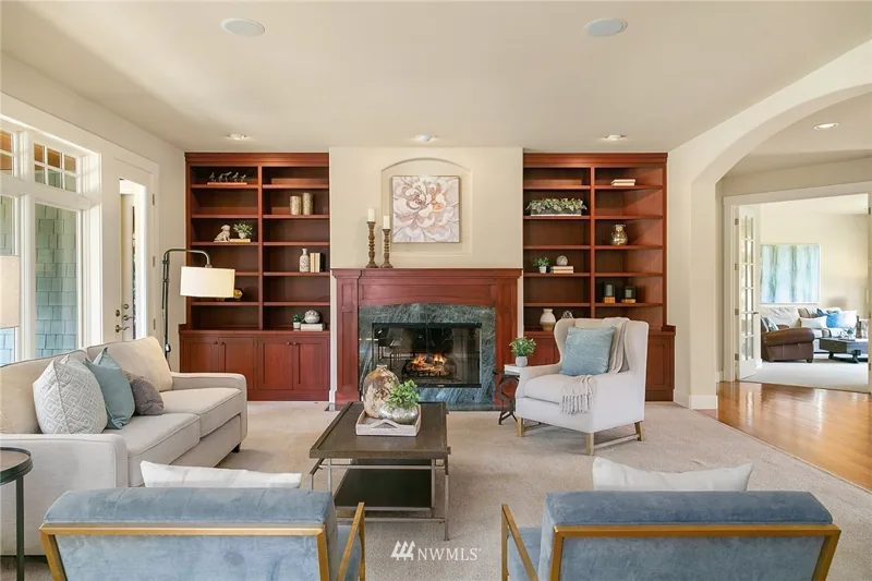 Family room fireplace framed by wood built-in shelves