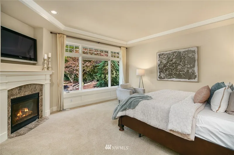 Bedroom with a fireplace and garden-facing window