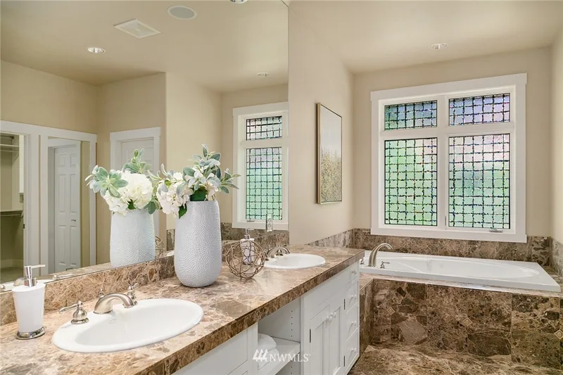 Bathroom with a double vanity, soaking tub and corner windows