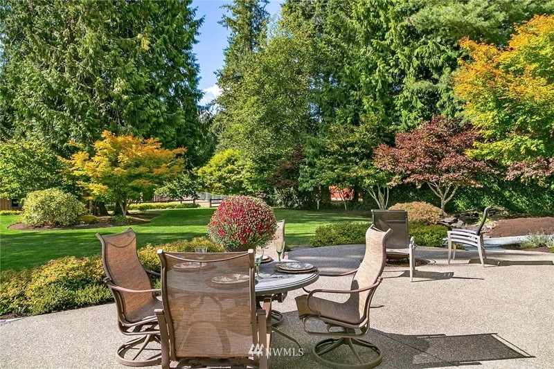 Garden patio with outdoor seating beside landscaped lawns