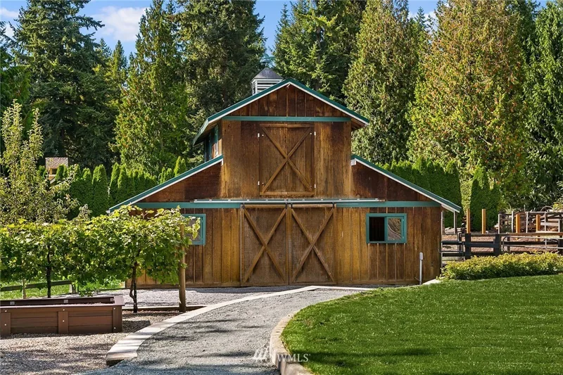 Wood outbuilding beside the driveway and gardens