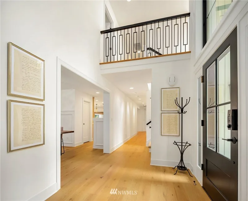 Entry hallway with wood flooring and an open staircase