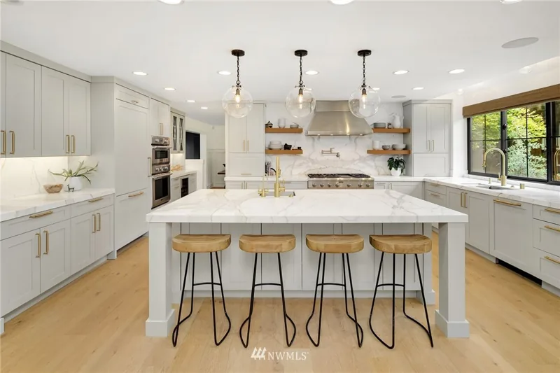 White kitchen with a large island and pendant lighting