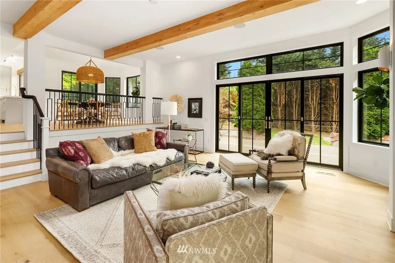 Living room with exposed ceiling beams and black-framed windows