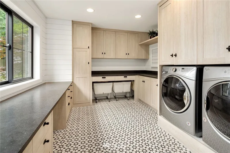 Laundry room with wood cabinetry and a patterned floor