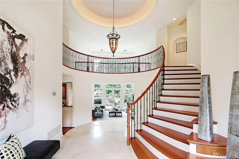Entry hall with a curved staircase and upper gallery