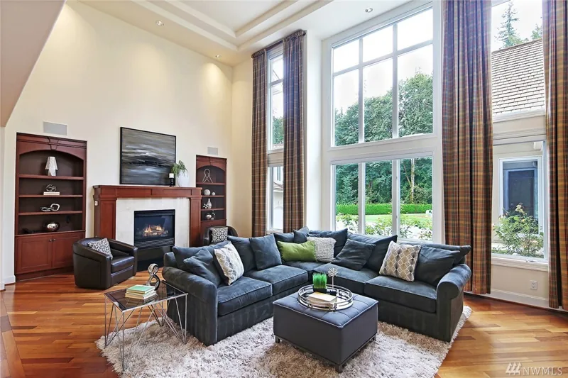 Family room with a fireplace and double-height windows