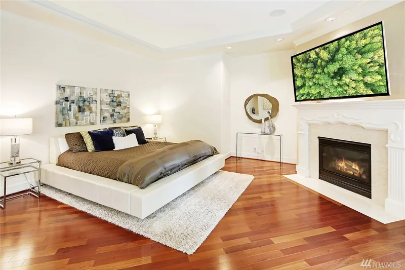 Bedroom with a fireplace and wood flooring