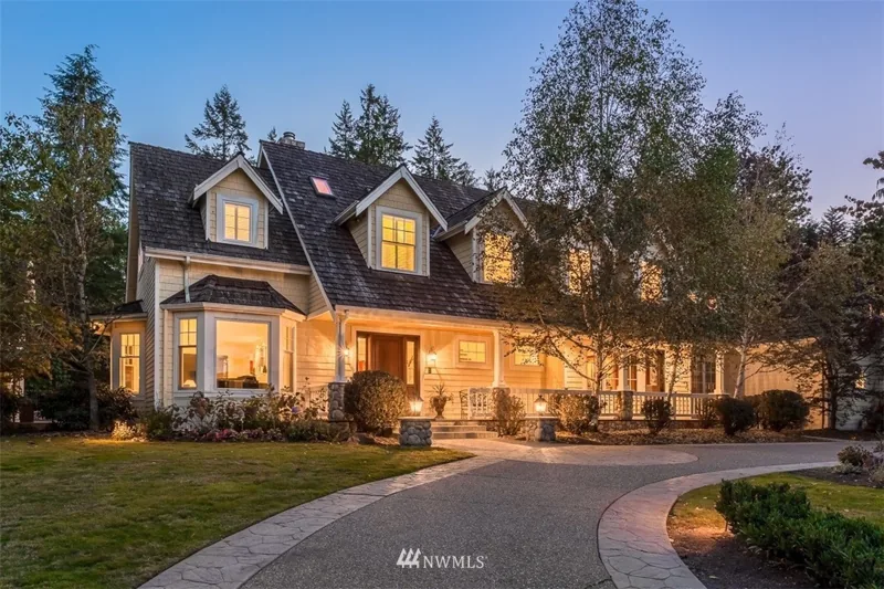 Gabled Woodinville home with illuminated windows at dusk