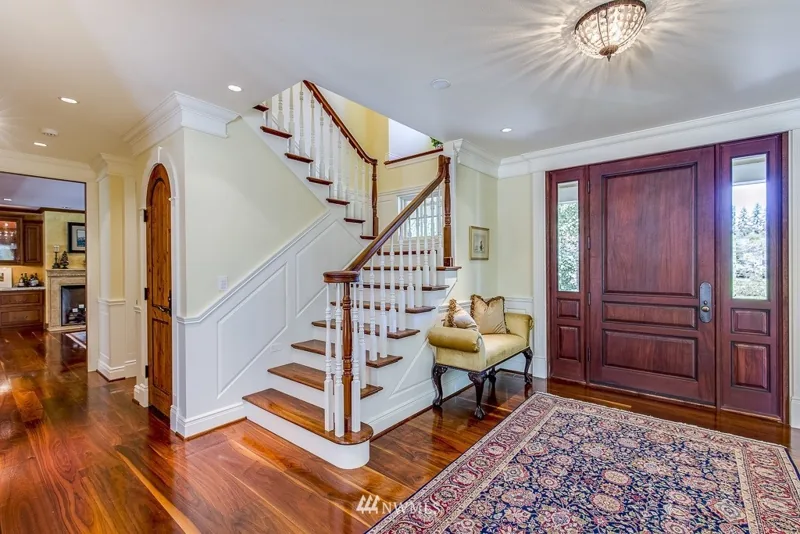 Entry hall with a wood front door and curved staircase