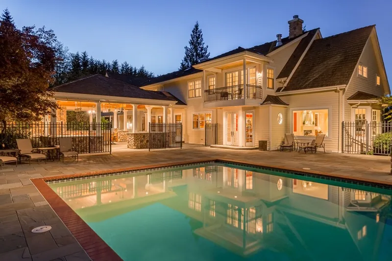 Illuminated swimming pool and rear of the home at dusk