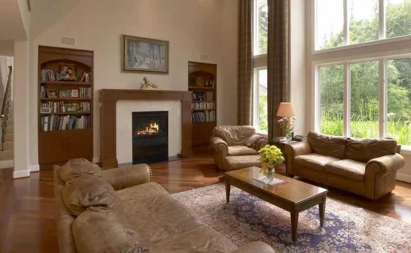 Woodinville, wine room and pool: Family room with tall windows, built-in shelving and a fireplace