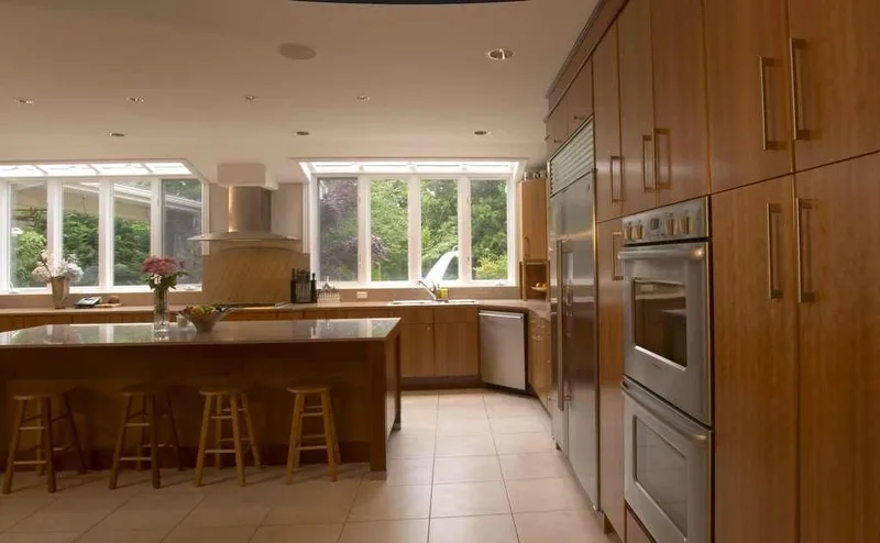 Woodinville, wine room and pool: Kitchen island beside the tall appliance cabinetry