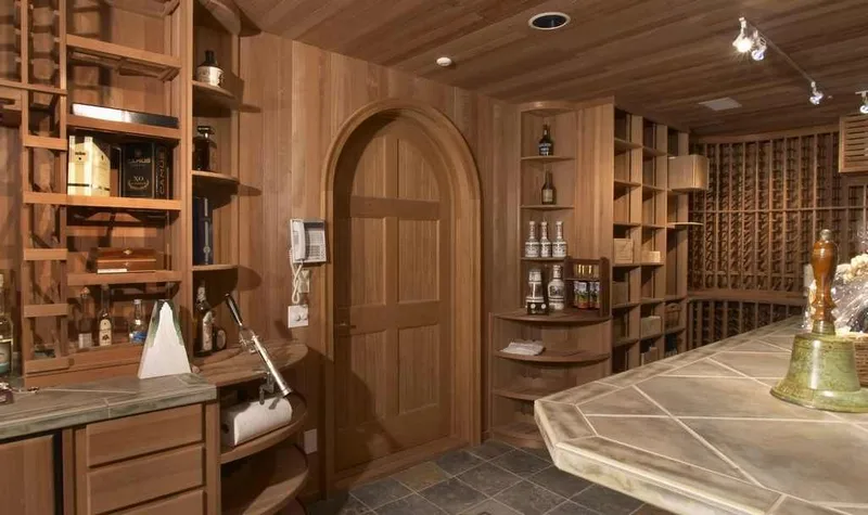 Woodinville, wine room and pool: Wine room entry with an arched wood door and display shelving
